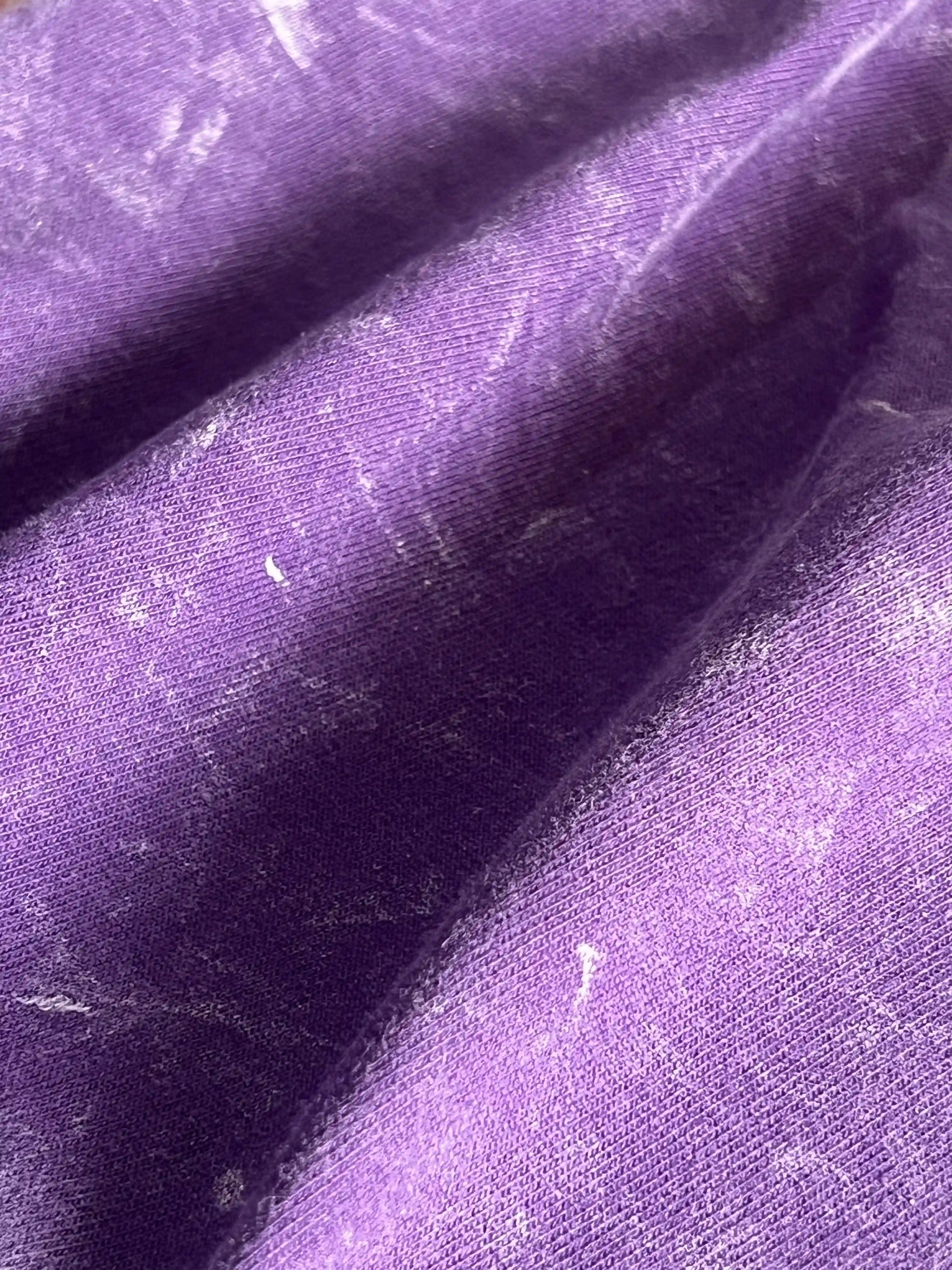 Close-up of fabric texture and print on Amethyst Acid Wash t-shirt – soft cotton with vintage purple finish