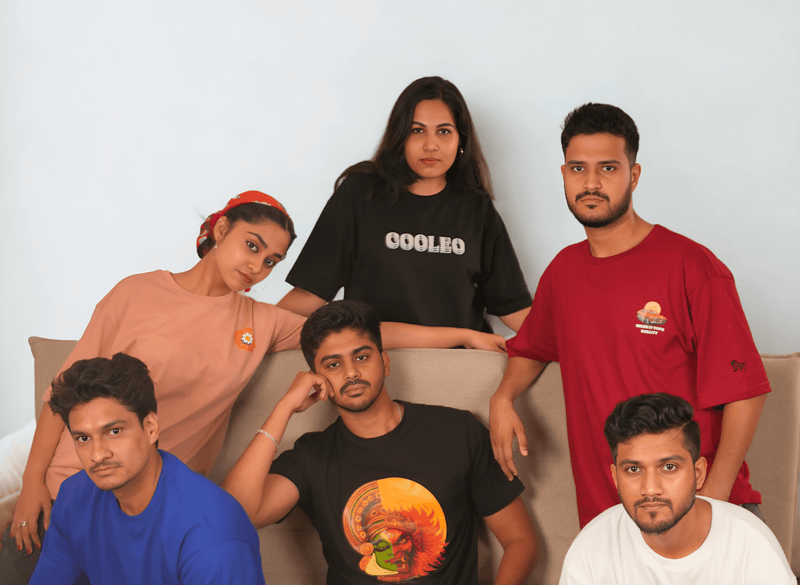 Group of six people posing together with a plain background